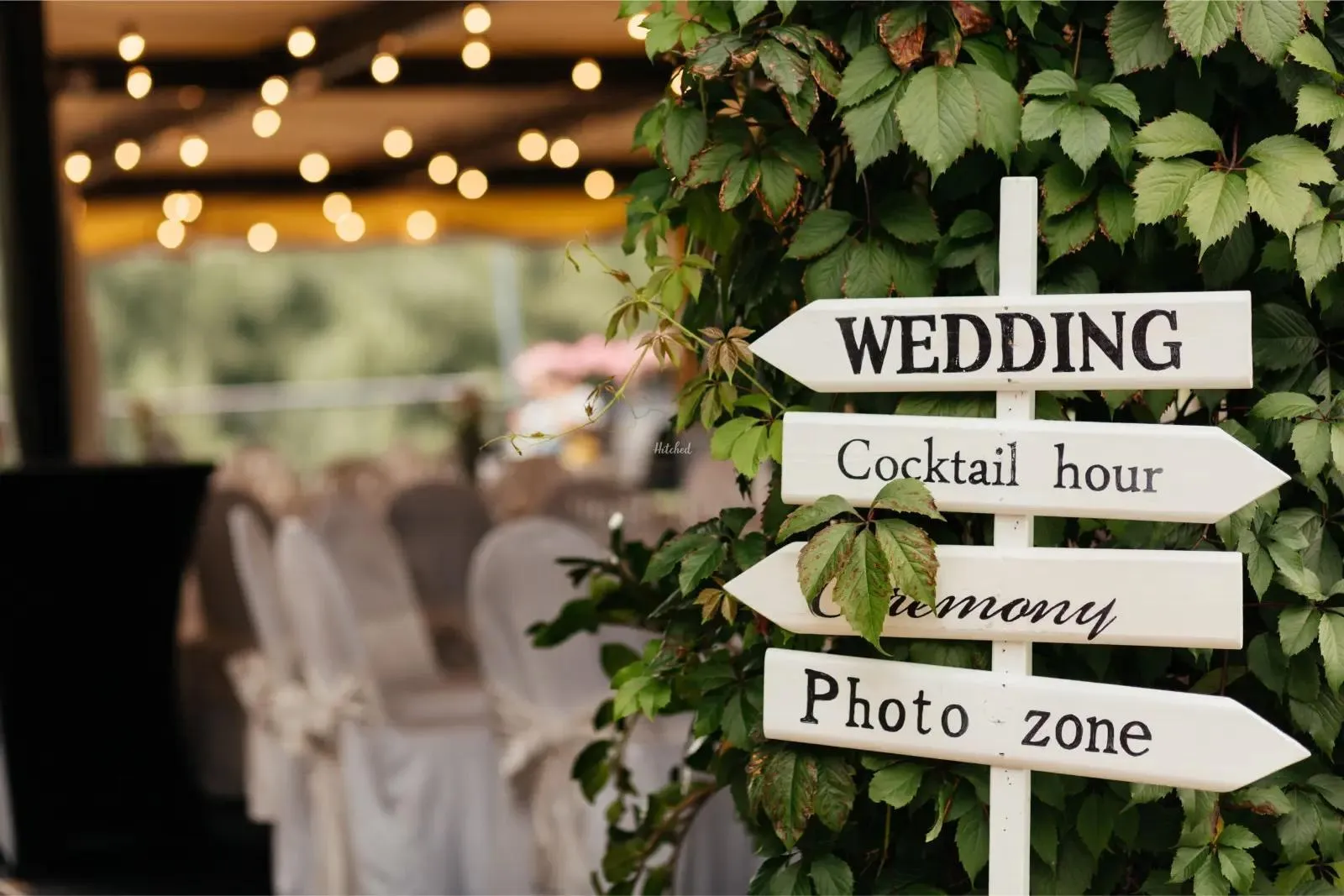 Wedding signpost pointing to ceremony and cocktail hour