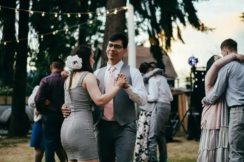 Guests dancing outdoors under festoon lights